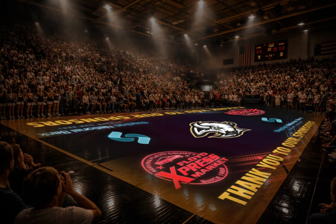 Packed high-school gym with sponsor logos projected on the court floor